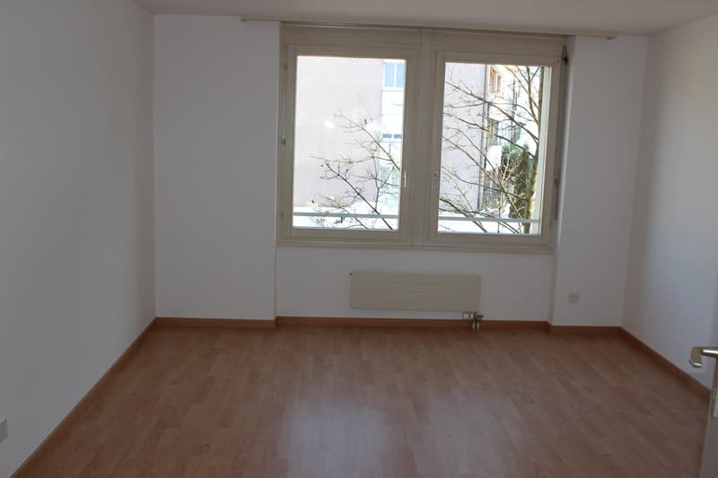 empty room, wooden floor, white walls, large window, heater