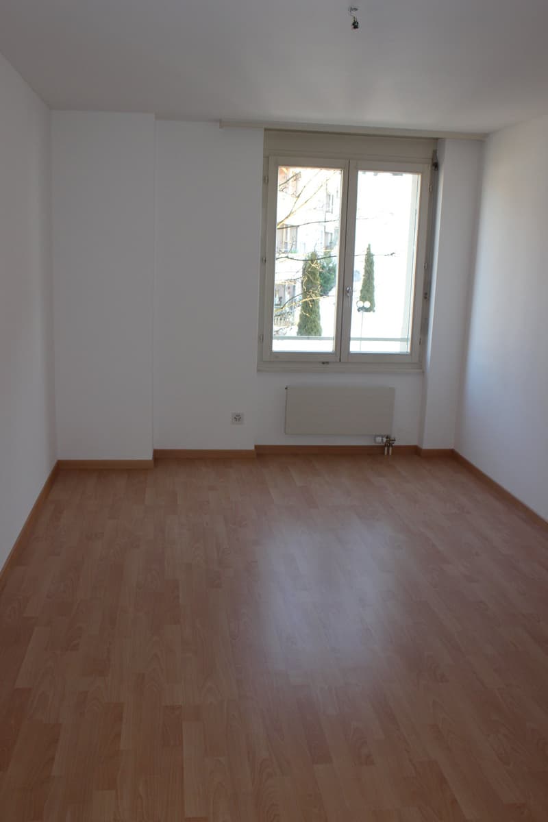 empty room, wooden floor, white walls, large window, white radiator