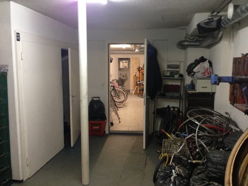 Large storage room with bicycles, tools, bags and baskets.