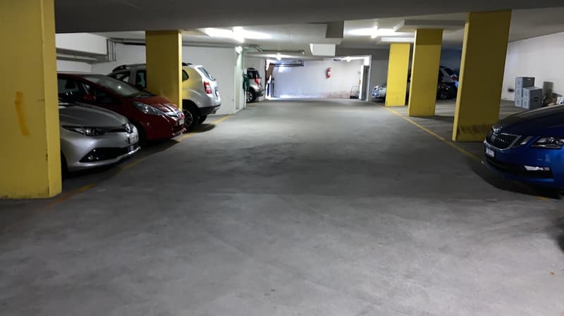 Empty parking space with yellow pillars and grey floor