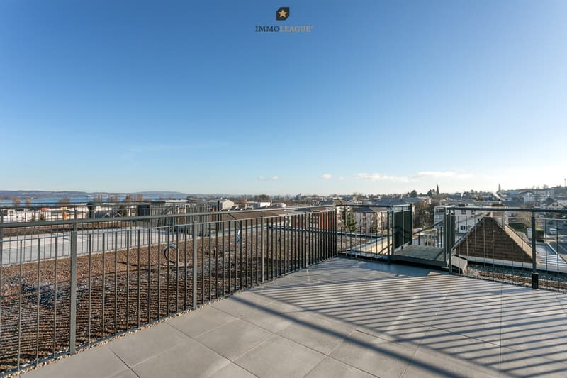 Von der Dachterrasse eröffnet sich ein weiter Blick über die umliegenden Dächer bis hin zum See.
