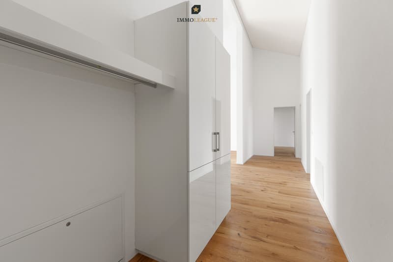 Integrierte LED-Spots, raumhohe Garderobenschränke und eingelassene Vorhangschienen verbinden klare Ästhetik mit durchdachter Funktionalität.