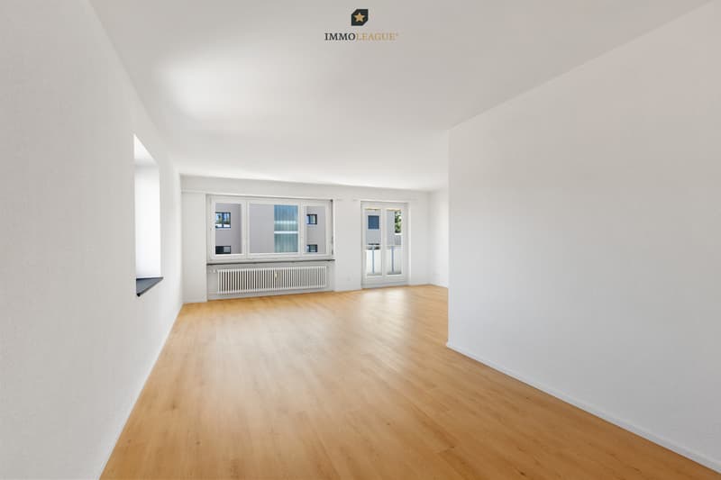 Grosszügiger und heller Wohnbereich mit direktem Zugang zum Balkon.