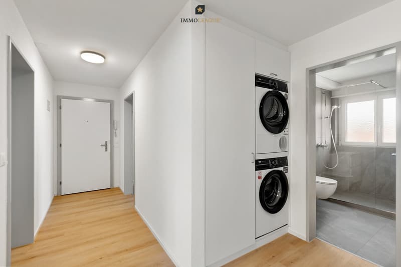 Heller und freundlicher Eingangsbereich mit praktischem Einbauschrank sowie integrierter Waschmaschine und Tumbler.