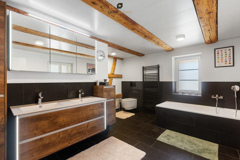 Exklusive Wellnessoase - grosszügiges Designbad mit Badewanne, Doppelwaschtisch und charmanten Holzbalken