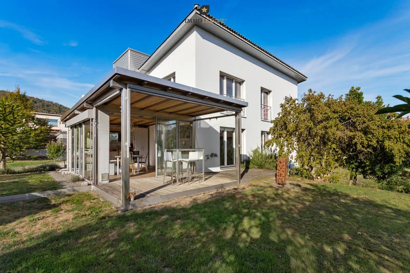 Der grosszügige, überdachte Sitzplatz lädt zum Verweilen ein und eröffnet einen wunderschönen Ausblick ins Grüne und nach Westen.