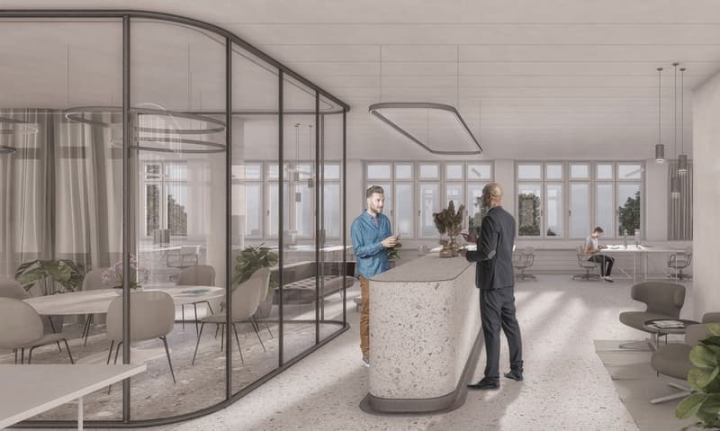 Modern open-plan office space with glass walls, high ceilings, and large windows providing natural light. The space includes a reception desk, seating areas, and workstations. There appears to be a balcony or terrace visible through the glass walls.
