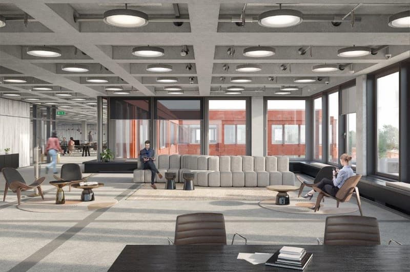 Large open space, modern decor, seating area with couches and chairs, tables, carpeted floor, multiple large windows, high ceiling with ceiling lights.