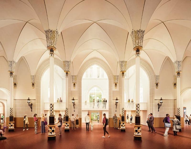 The image shows the interior of a large, ornate building with high ceilings and arched windows. The space is filled with people, and features decorative columns, chandeliers, and intricate architectural details. The floor is tiled in a checkered pattern.