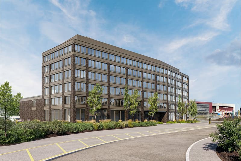 Modern office building with glass windows, brown facade, parking area in front