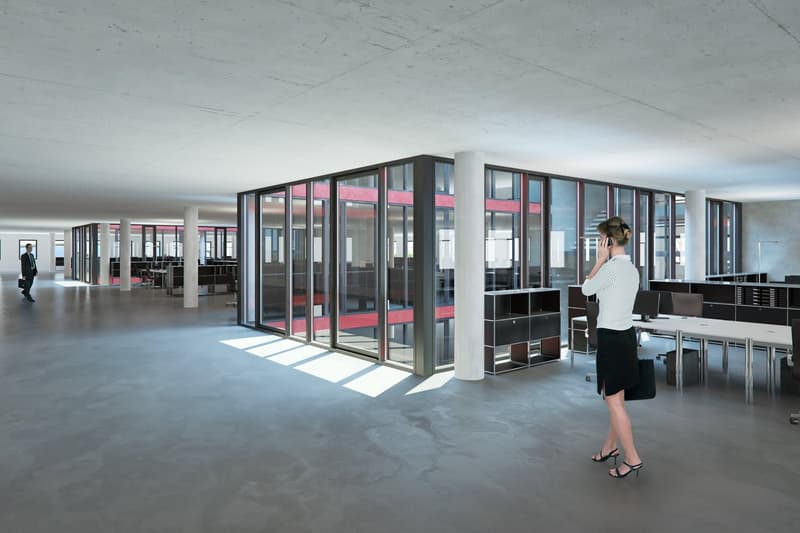 Large open space, glass walls, concrete floor, offices with desks,  people