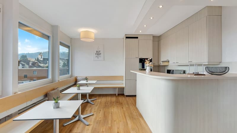 modern kitchen with wooden floor, white walls, large windows, kitchen island, built-in cabinets, microwave, refrigerator, dining table, benches, plants