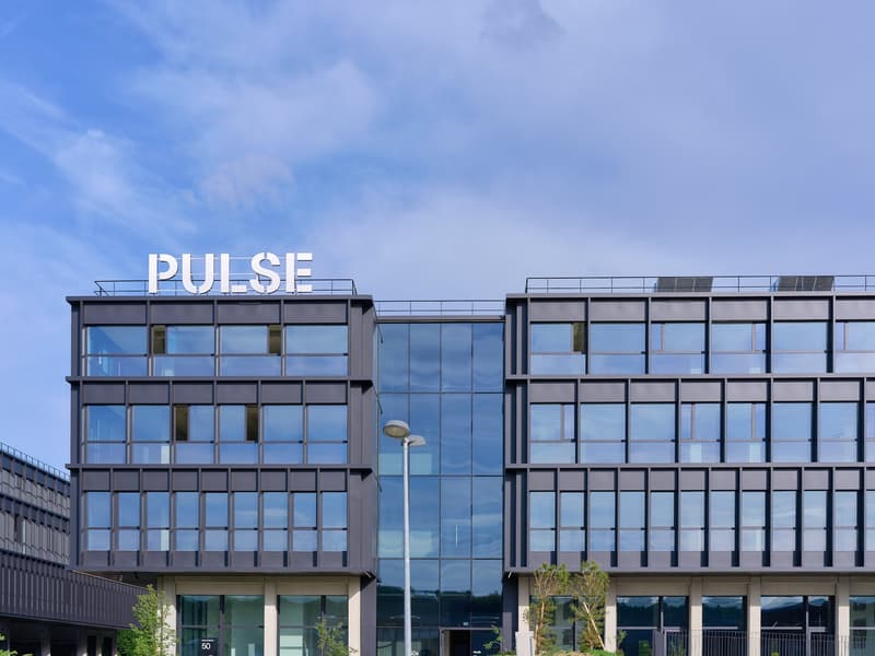 modern office building, large glass windows, rooftop terrace, solar panels