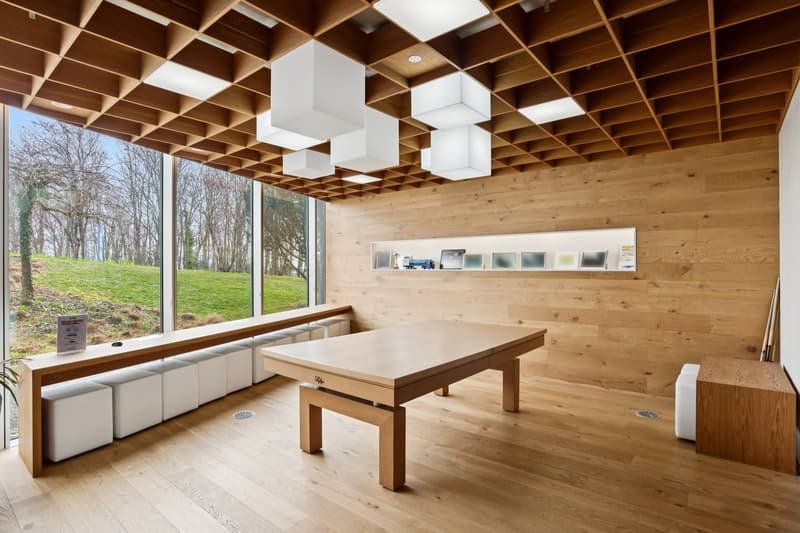 wooden walls, wooden floor, large windows, billiard table, bench seating, wooden ceiling with lights