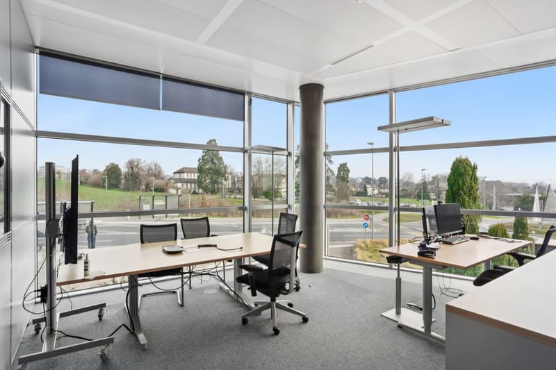 modern office, large windows, desks, chairs, computer monitors, office equipment