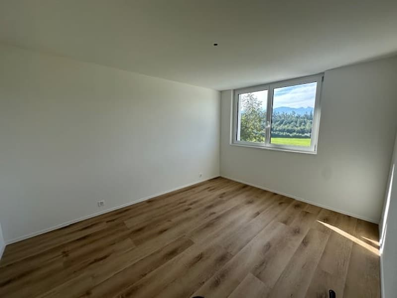 empty room, wooden floor, white walls, large window with view of the outside