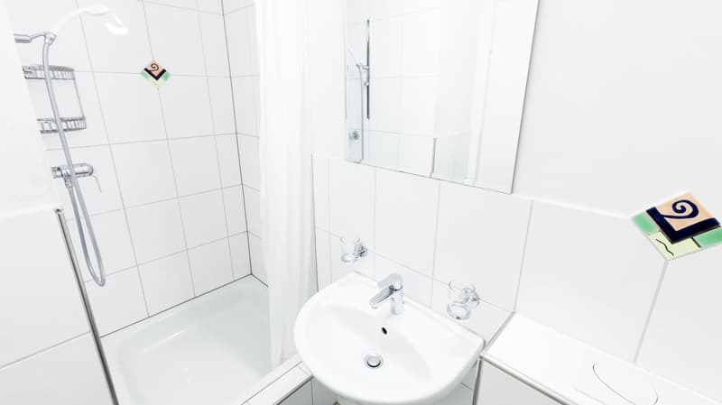 Bathroom with shower, bathtub, sink, mirror, and tiled walls