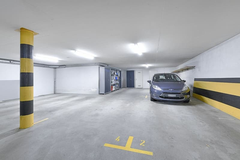 2 Parkplätze hintereinander in der Einstellhalle, dahinter der eigene Kellerraum