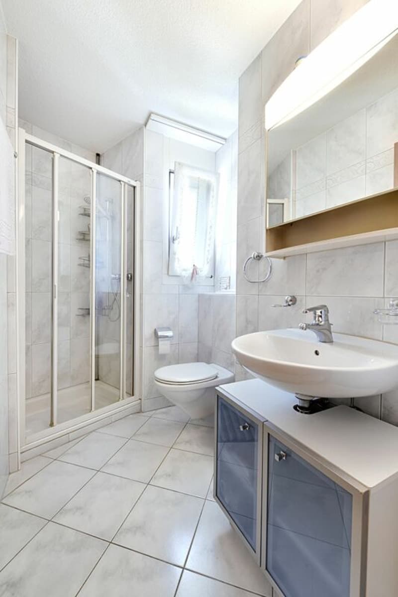 Kleines Badezimmer mit Dusche, WC, Lavabo mit Unterbaumöbel und Fenster