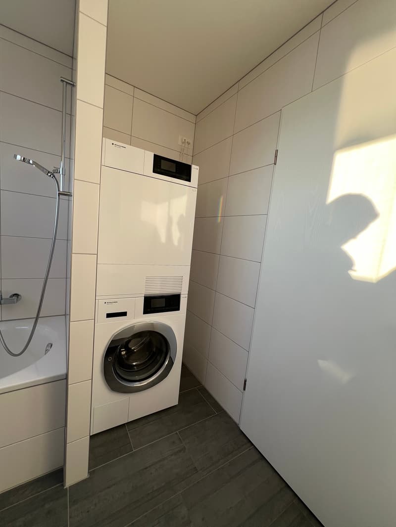 white shower, bathtub, white appliances, tiled walls