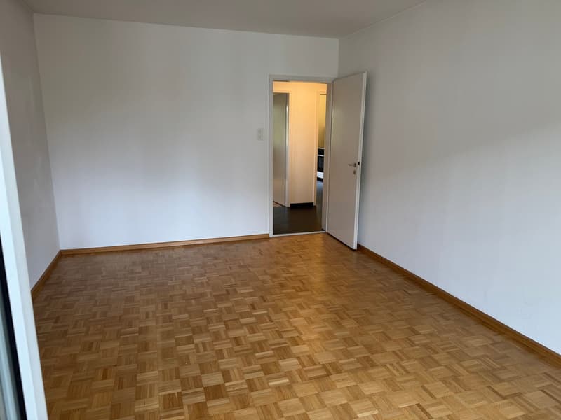 empty room, wooden parquet floor, white walls, open door, hallway