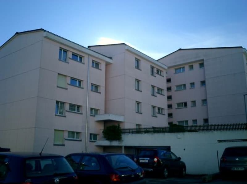 multi story apartment building, several cars parked in front