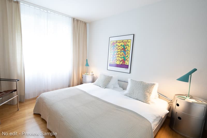 Double bed, pillows, blankets, bedside lamps, night tables, art painting on wall, wooden flooring, chair