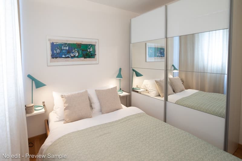 double bed, bedside table with lamp, nightstand on the other side of the bed, sliding door with mirror, white curtains, artwork