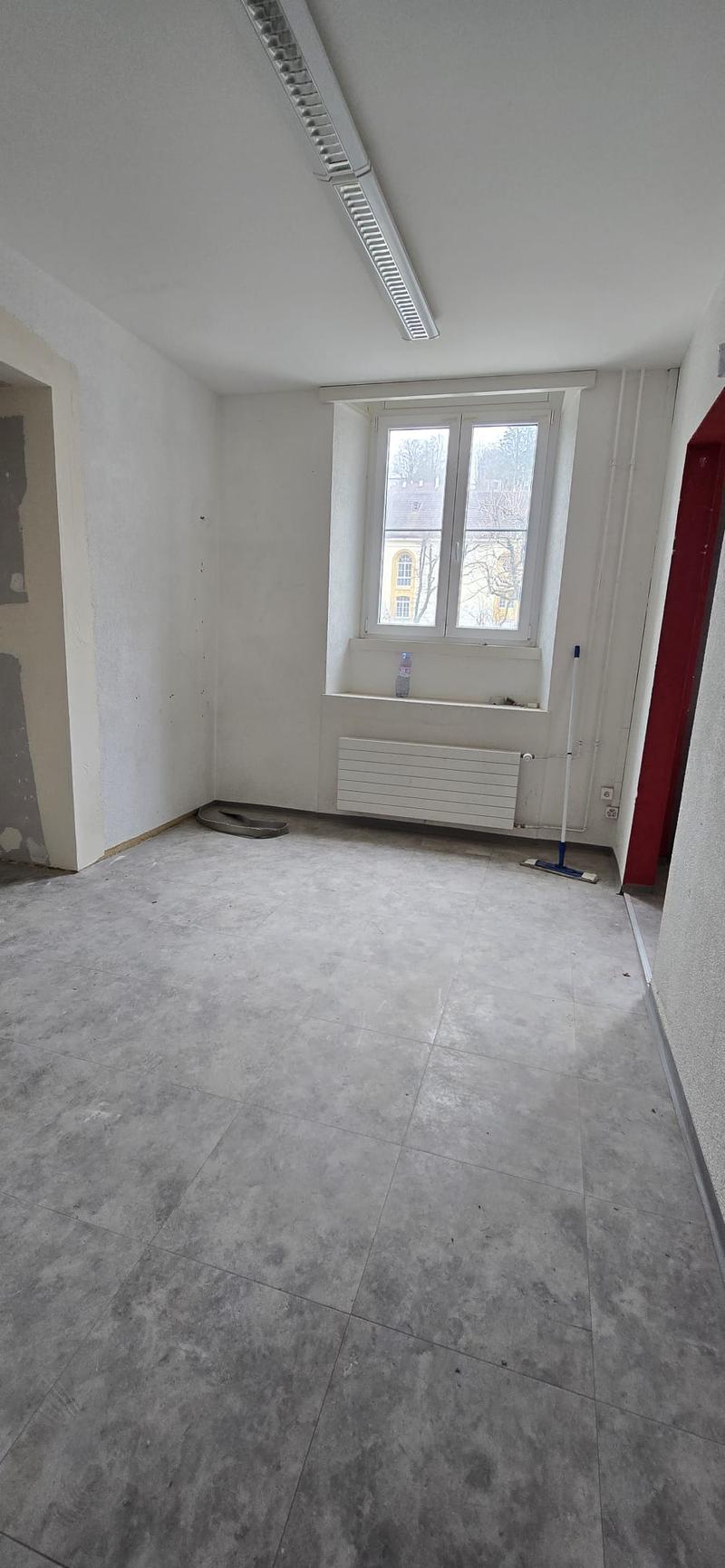empty room, white walls, tiled floor, large window, heater on wall, door to another room