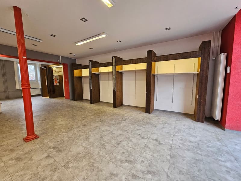 Empty room, tiled floor, wooden columns, ceiling lights, shelves, metal column