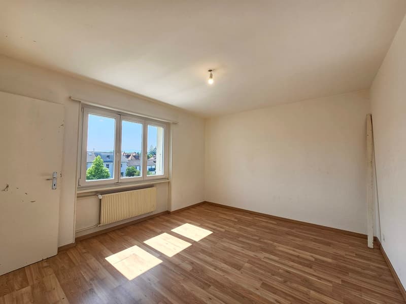 Wooden floors, white walls, white door, double windows, white radiator, bright with natural light