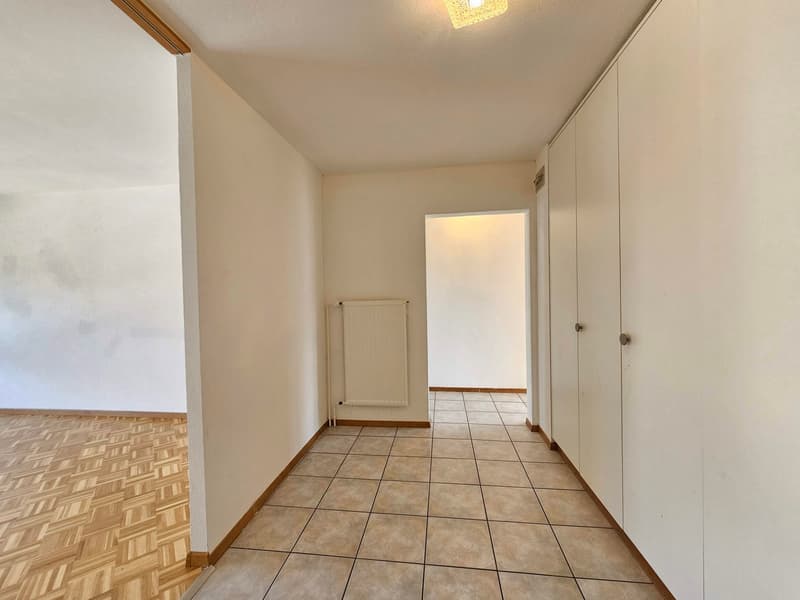 Spacious room with white walls, tile flooring, and a closet. The room appears to be empty and ready for furnishing.
