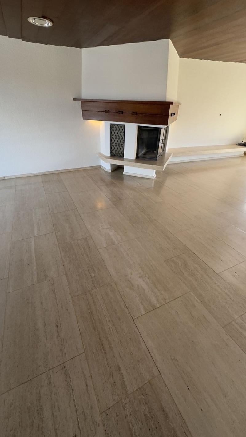 Hardwood flooring, white walls, fireplace with wooden mantel and decorative grate