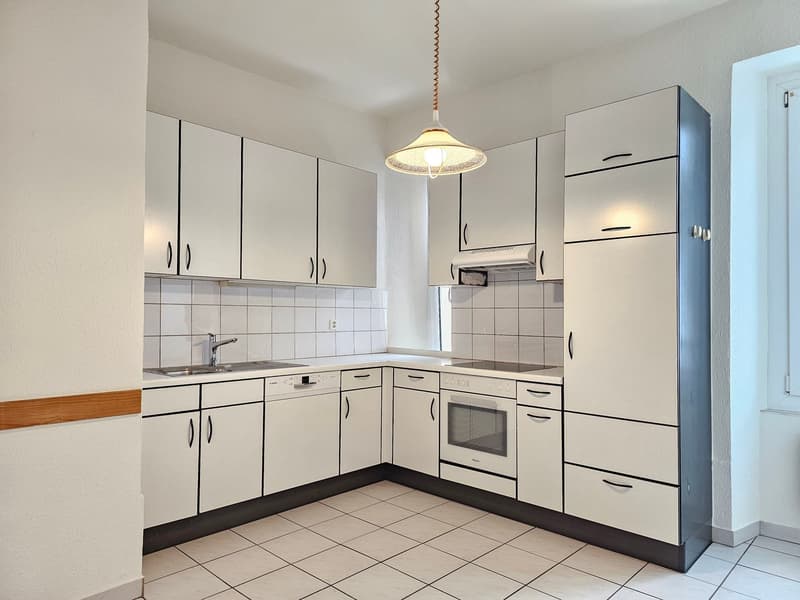 modern kitchen with white cabinets, white tiled floor, dishwasher, washing machine, gas stove, oven, sink with faucet, tiled backsplash, light fixture