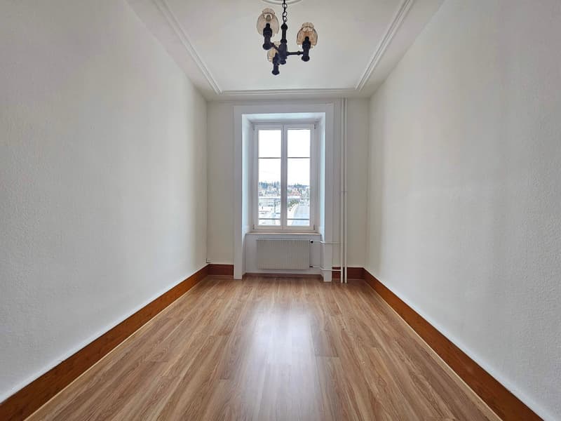 wooden floor, white walls, windows with a view, hanging lamp, radiator