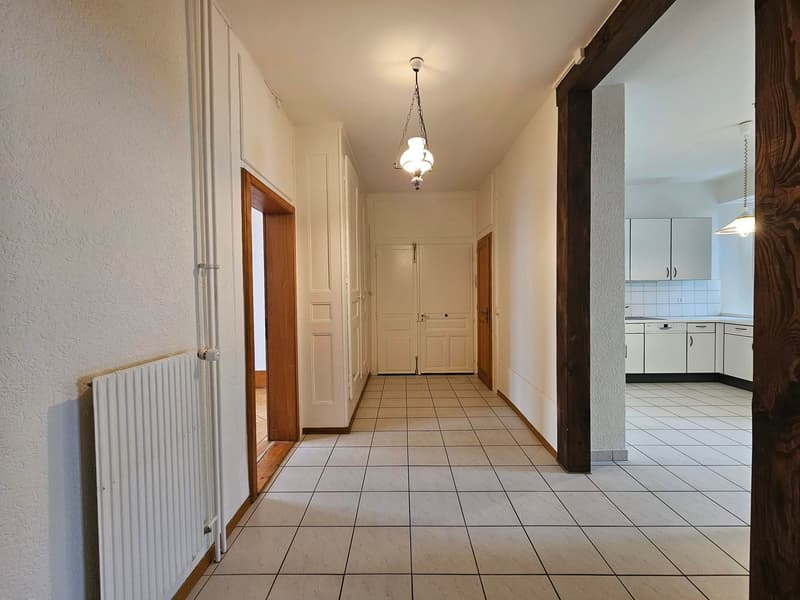 tiled floor, white walls, pendant lights, white cabinet, kitchen area