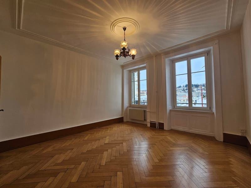 spacious room, wooden herringbone flooring, 2 large windows, radiator, chandelier, city view