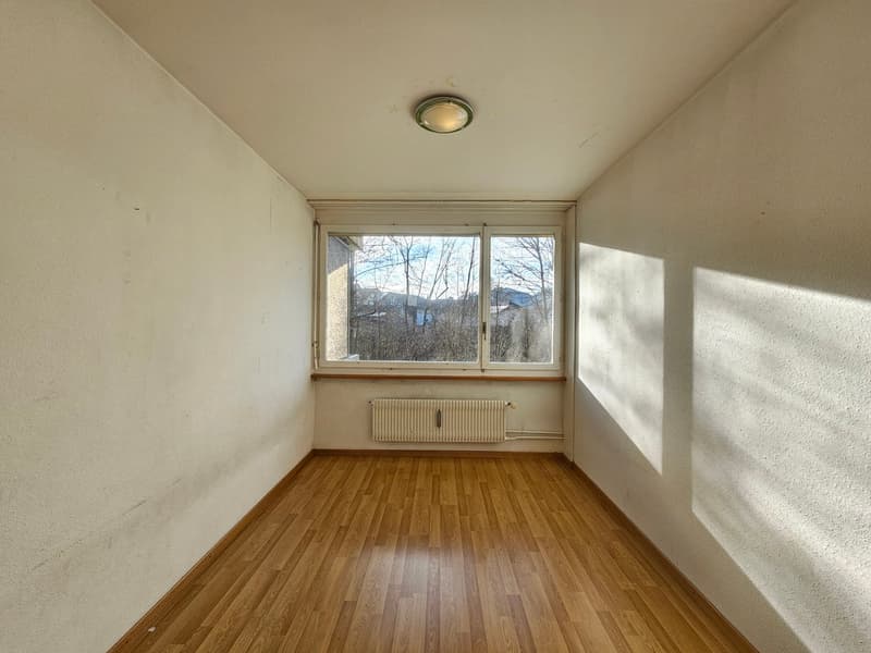 empty room, white walls, wooden floor, large window with trees view