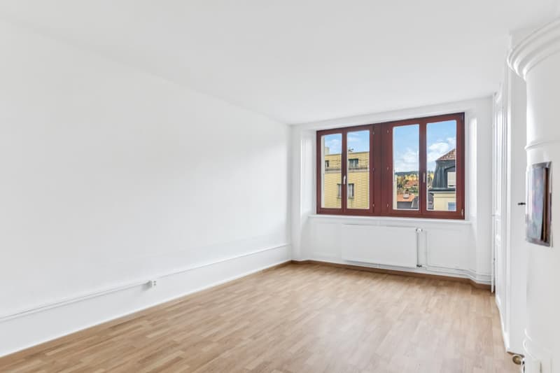 empty room, white walls, wooden floor, large window, white radiator, electrical outlet