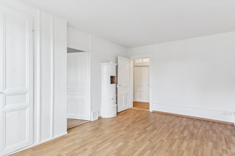 Empty room, wooden floors, fireplace, white walls, power outlet, doors