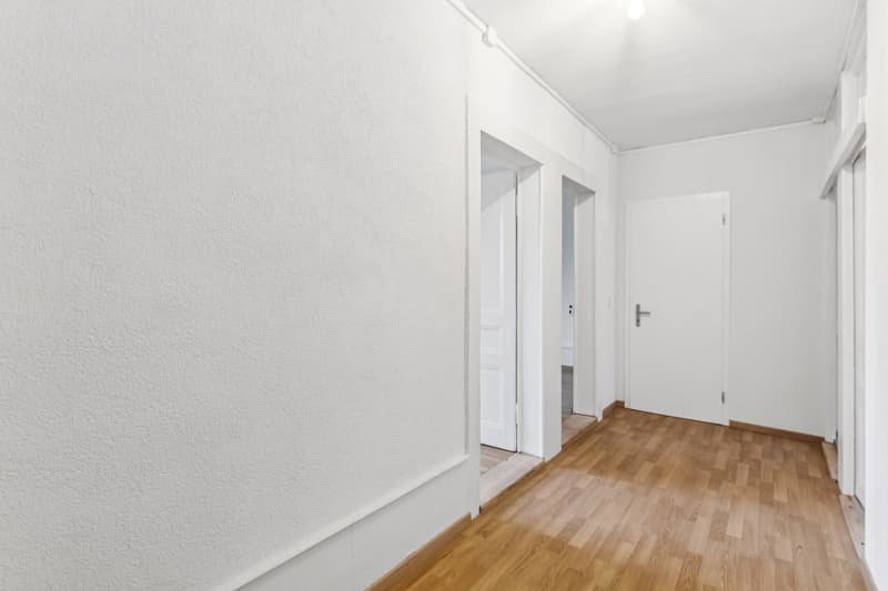 empty hallway, white walls, wooden floor, two doors