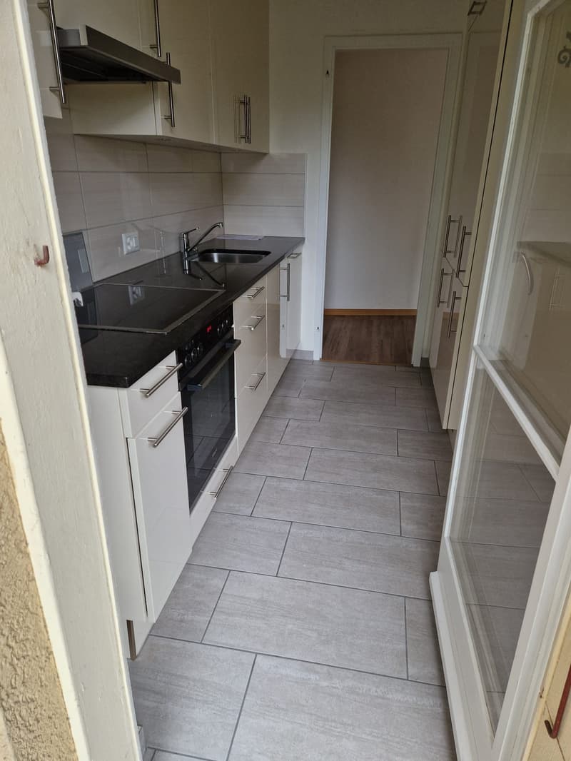 Open kitchen with stove, oven, sink, kitchen cabinets, floor outlet, tiled floor, white doors