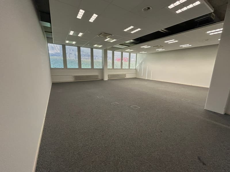 empty room, large windows, white walls, white ceiling, gray floor, white pillars, HVAC