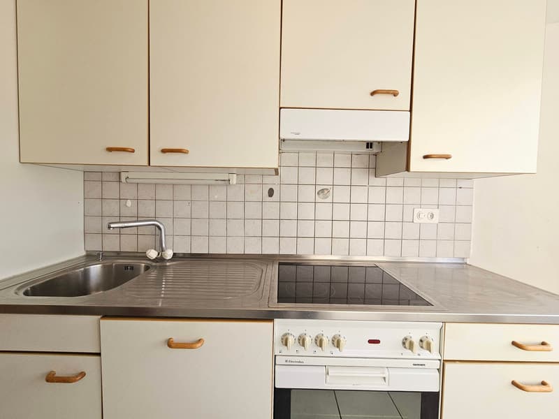 Modern kitchen with sink, oven, dishwasher, and faucet