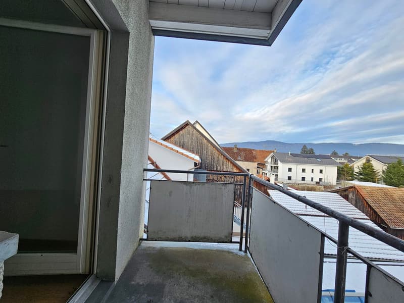A balcony with an open doorway to a room, metal railing, with an unobstructed view to the outside.
