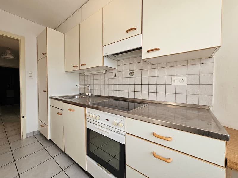 white cabinets, tile flooring, white oven and stove, silver countertop, sink, faucet