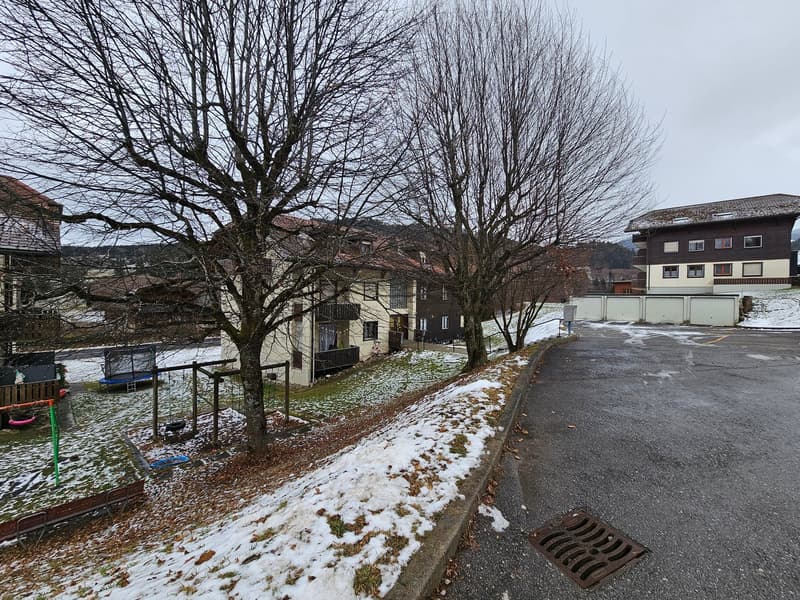 Snowy street, residential buildings, garage, trees, playground, streetlight, drain cover
