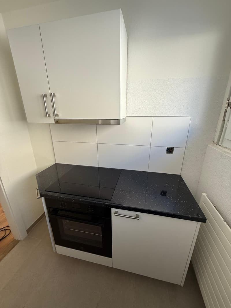 modern kitchen, white cabinetry, black granite countertop, built-in oven and stove, under cabinet lighting, extractor fan, modern appliances