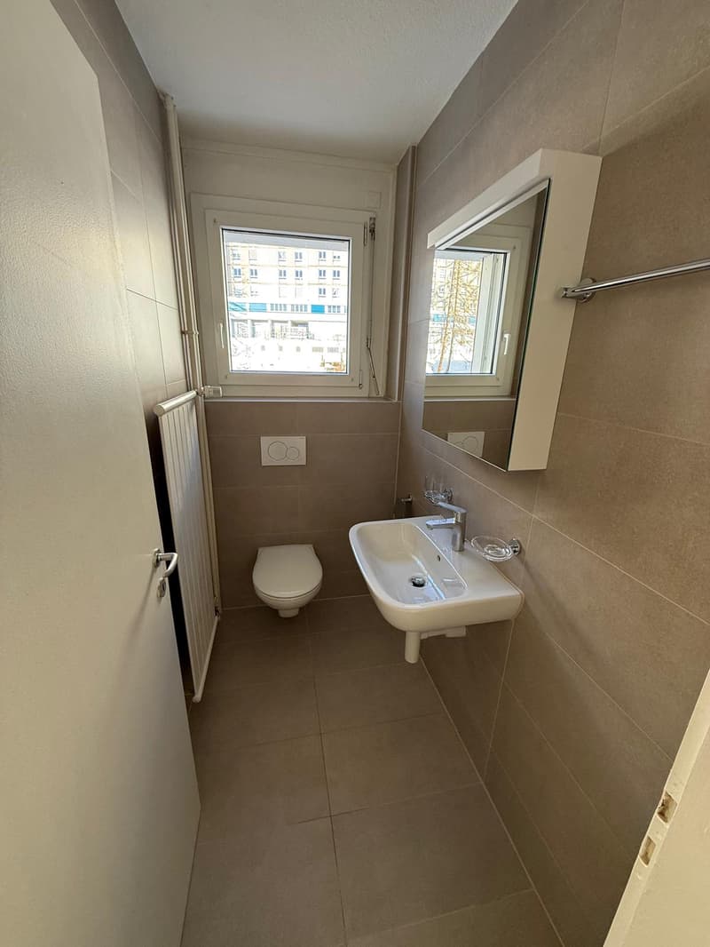 modern washroom with toilet, sink and mirror