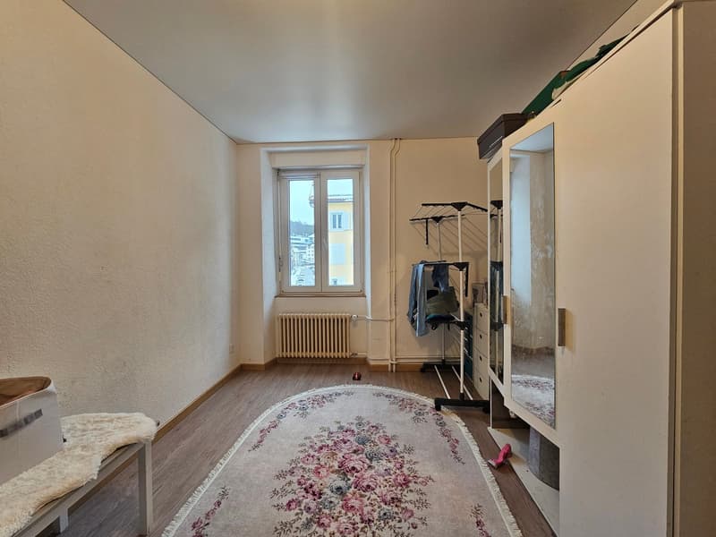 empty room with white walls, window, wardrobe, radiator, rug